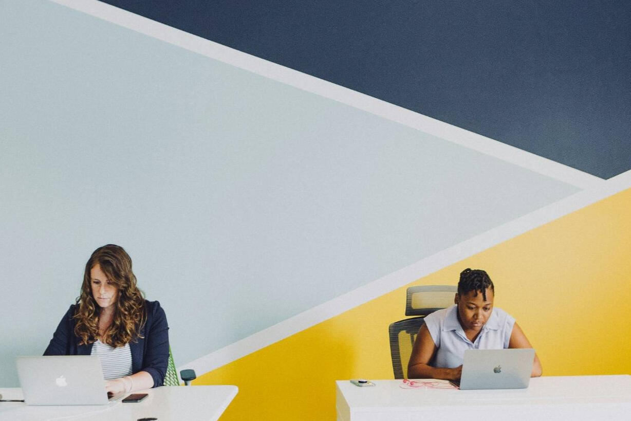 placement de ressources TI qualifiées Deux professionnels travaillant sur ordinateur dans un bureau moderne – placement de ressources TI qualifiées